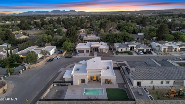 aerial view at dusk featuring a residential view and a mountain view