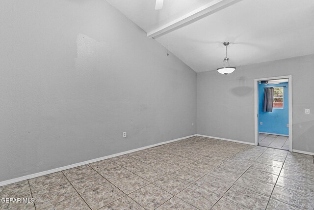 spare room featuring tile patterned floors, lofted ceiling, and baseboards