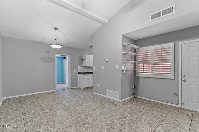 interior space with light tile patterned flooring, visible vents, high vaulted ceiling, and baseboards