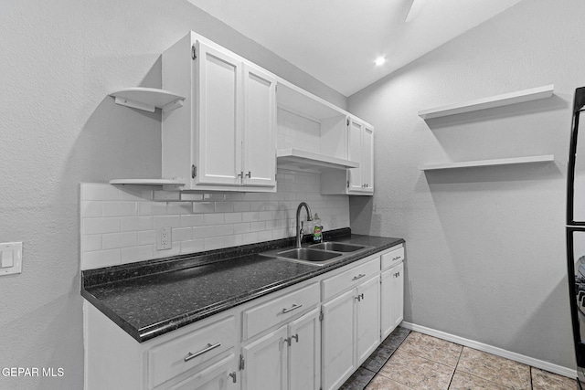 kitchen featuring backsplash, white cabinetry, open shelves, and a sink