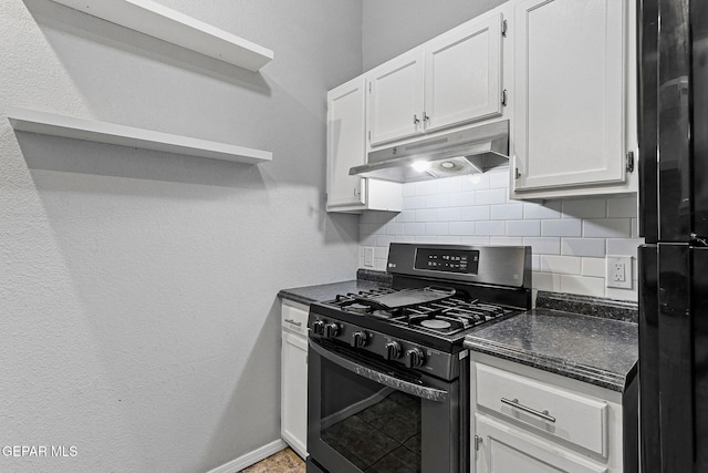 kitchen featuring white cabinetry, tasteful backsplash, freestanding refrigerator, gas range, and under cabinet range hood