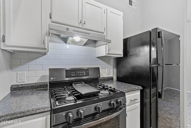 kitchen featuring stainless steel range with gas cooktop, visible vents, dark countertops, and under cabinet range hood