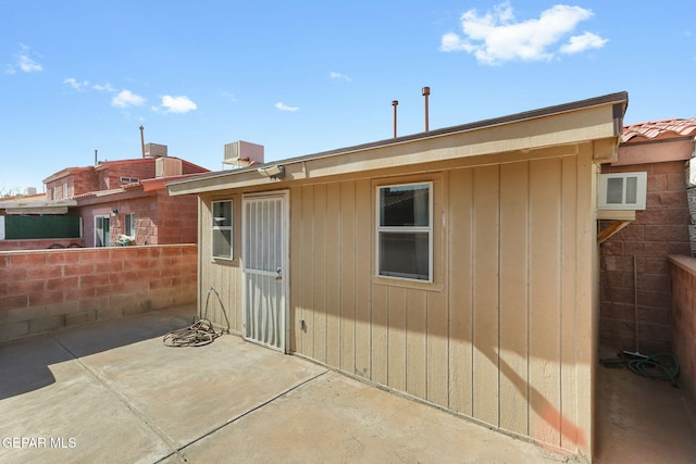 back of property with fence, a tiled roof, and a patio area