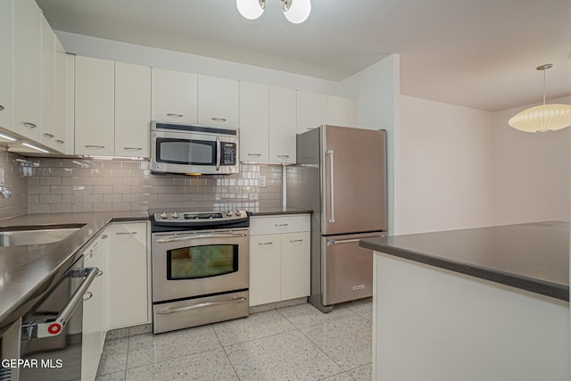1800 N Stanton Unit 502, El Paso, TX 79902 - kitchen with light speckled floor, dark countertops, a sink, decorative backsplash, and appliances with stainless steel finishes