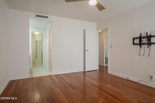 1800 N Stanton Unit 502, El Paso, TX 79902 - unfurnished bedroom featuring a ceiling fan, wood finished floors, baseboards, ensuite bath, and visible vents