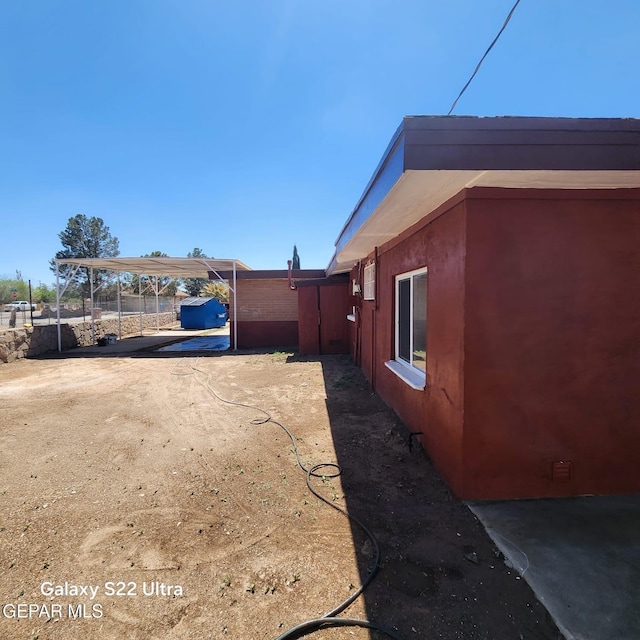 exterior space featuring a carport and fence