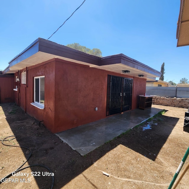 exterior space featuring stucco siding, fence, and a patio