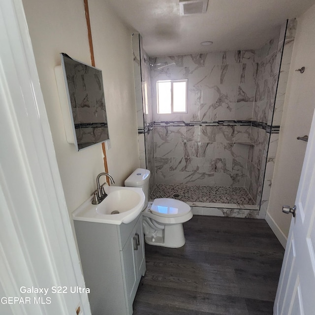 bathroom featuring visible vents, toilet, a stall shower, and vanity