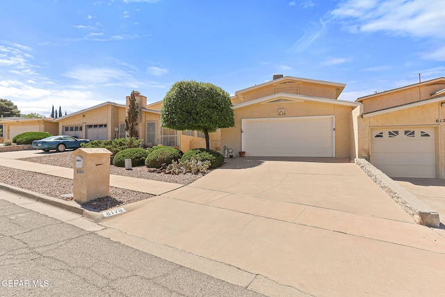 6170 Los Robles Dr, El Paso, TX 79912 - view of front of house with concrete driveway, an attached garage, and stucco siding