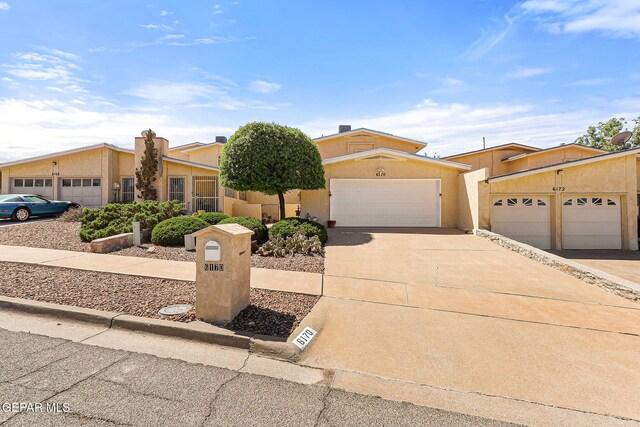 6170 Los Robles Dr, El Paso, TX 79912 - view of front of home with stucco siding, driveway, and an attached garage
