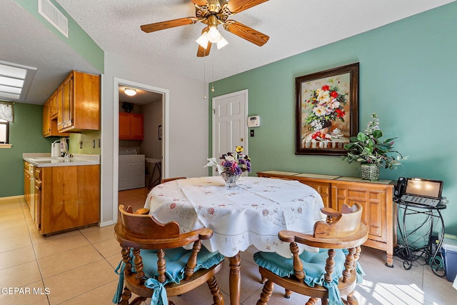 6170 Los Robles Dr, El Paso, TX 79912 - dining room featuring a ceiling fan, light tile patterned floors, a textured ceiling, and washing machine and clothes dryer