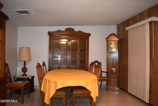 632 Mauer Rd, El Paso, TX 79915 - dining space with a textured ceiling, light tile patterned floors, and wooden walls