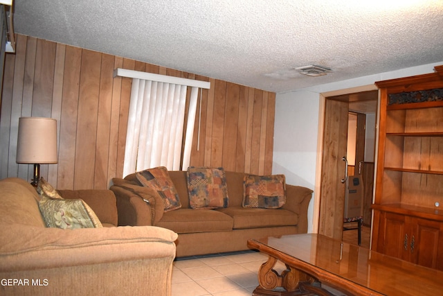 632 Mauer Rd, El Paso, TX 79915 - living room featuring wood walls, light tile patterned flooring, and a textured ceiling
