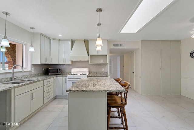 9668 Kathy Ave, El Paso, TX 79927 - kitchen with visible vents, a sink, stainless steel microwave, white gas range oven, and custom exhaust hood