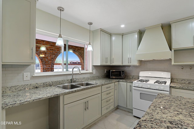 9668 Kathy Ave, El Paso, TX 79927 - kitchen featuring tasteful backsplash, a sink, white range with gas stovetop, premium range hood, and stainless steel microwave
