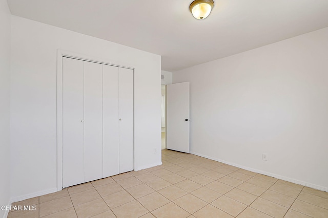 9668 Kathy Ave, El Paso, TX 79927 - unfurnished bedroom with light tile patterned floors, baseboards, and a closet