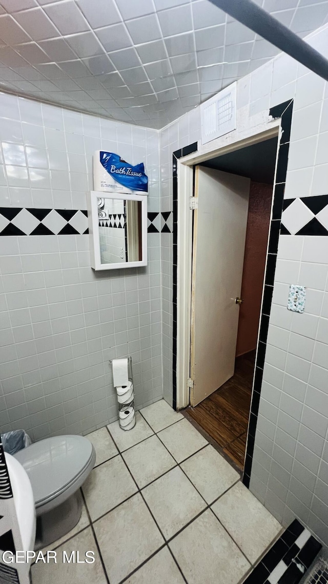 610 Jewels Dr, Socorro, TX 79927 - bathroom with toilet, tile patterned flooring, and tile walls