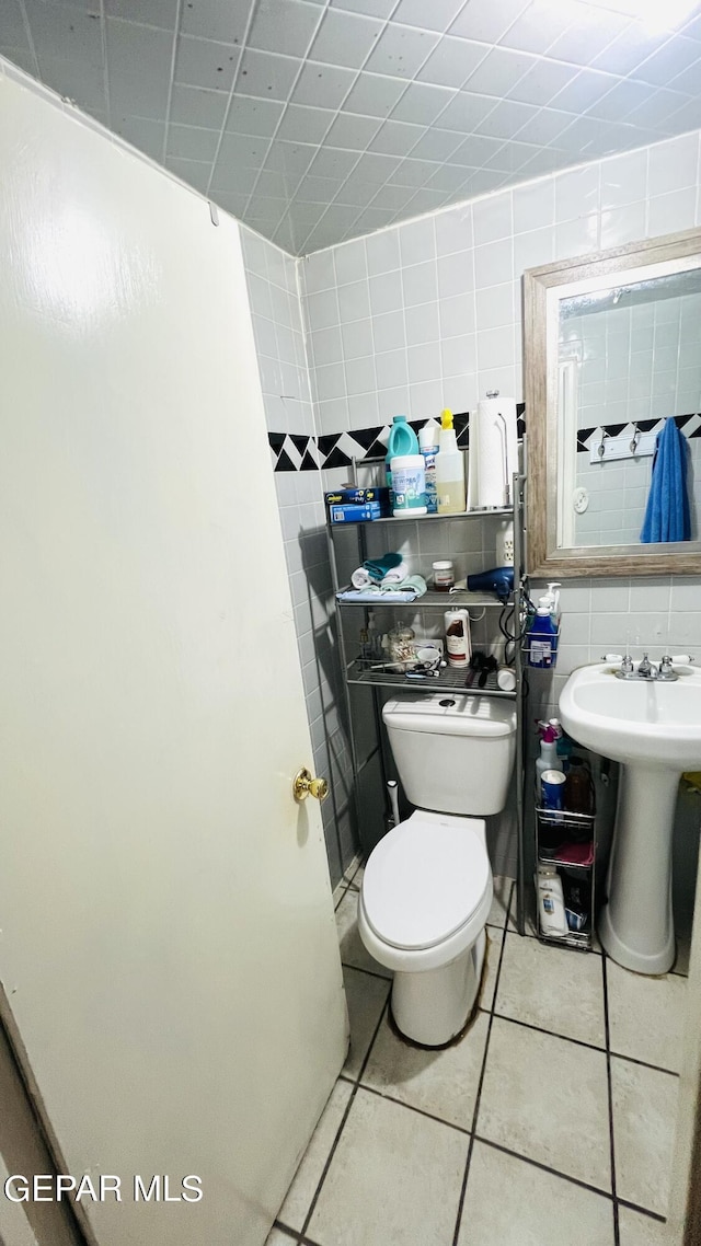 610 Jewels Dr, Socorro, TX 79927 - half bath featuring tile walls, tile patterned flooring, a sink, and toilet