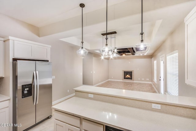 11969 Medalla St, Socorro, TX 79927 - kitchen featuring stainless steel fridge with ice dispenser, white cabinetry, hanging light fixtures, and light countertops