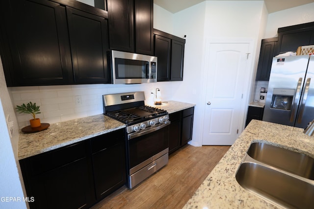 1628 Sam Dominguez, El Paso, TX 79928 - kitchen with dark cabinets, appliances with stainless steel finishes, decorative backsplash, and a sink