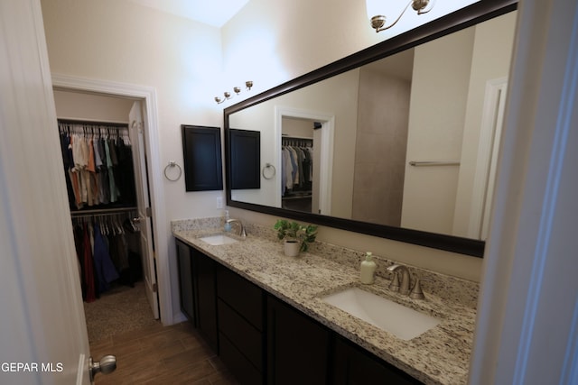 1628 Sam Dominguez, El Paso, TX 79928 - bathroom featuring a spacious closet, wood finished floors, a sink, and double vanity