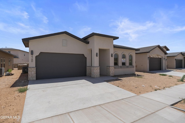 3780 Surmise St, El Paso, TX 79938 - view of front of property featuring a garage, stone siding, concrete driveway, stucco siding, and central AC