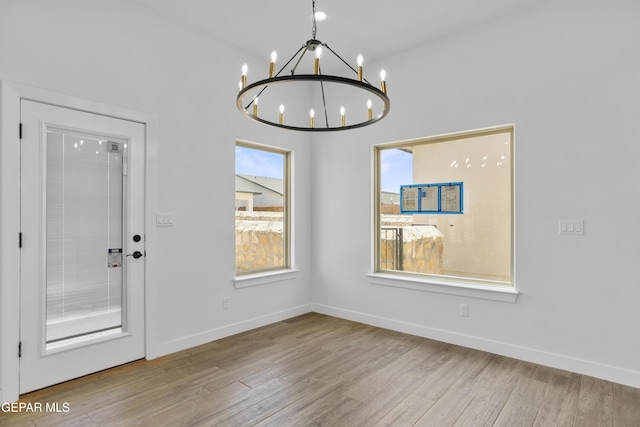3780 Surmise St, El Paso, TX 79938 - unfurnished dining area featuring a chandelier, wood finished floors, and baseboards