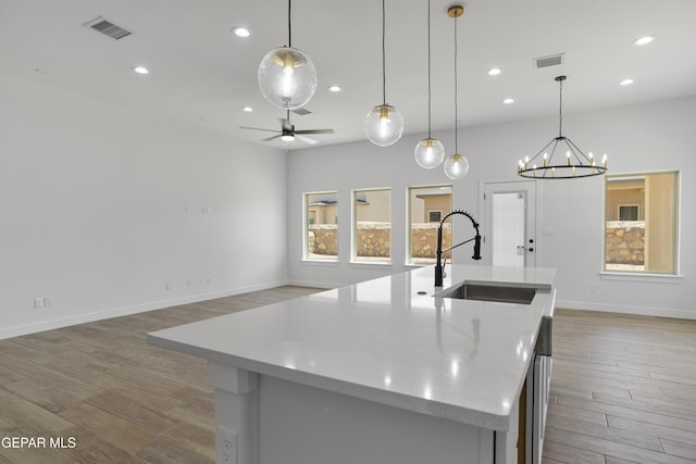 3780 Surmise St, El Paso, TX 79938 - kitchen with a sink, recessed lighting, wood finished floors, a center island with sink, and a chandelier