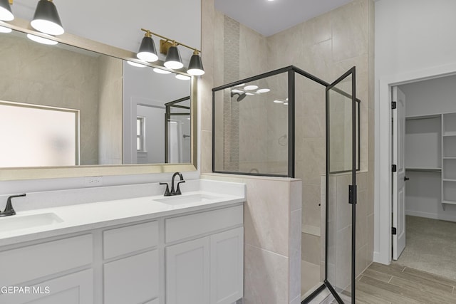 3780 Surmise St, El Paso, TX 79938 - full bath featuring a stall shower, double vanity, a walk in closet, and wood finished floors