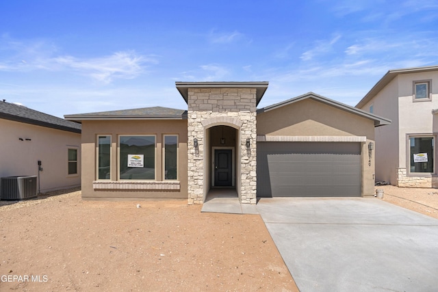3749 Focus Pl, El Paso, TX 79938 - view of front facade featuring an attached garage, stucco siding, stone siding, driveway, and central AC
