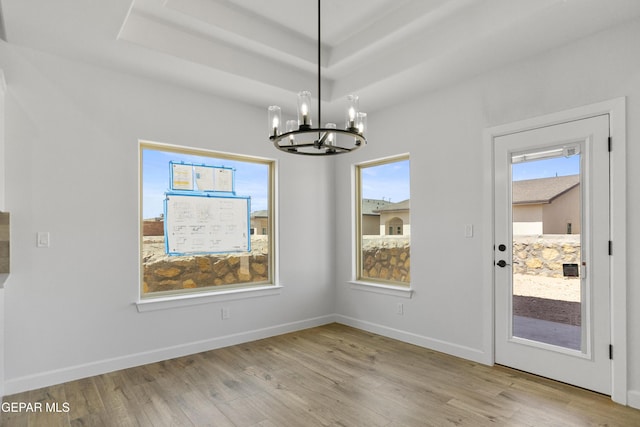 3749 Focus Pl, El Paso, TX 79938 - unfurnished dining area featuring a chandelier, wood finished floors, baseboards, and a raised ceiling