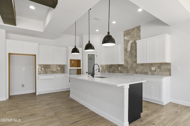 3749 Focus Pl, El Paso, TX 79938 - kitchen featuring a sink, backsplash, light wood finished floors, a center island with sink, and light countertops