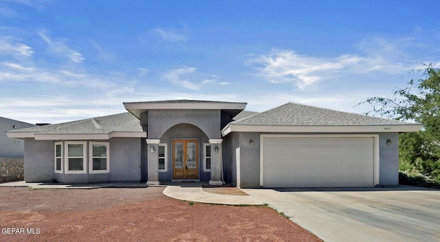 view of front of house with stucco siding, an attached garage, driveway, and a shingled roof