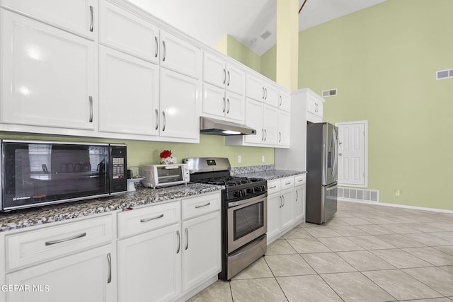 kitchen with white cabinets, stainless steel appliances, visible vents, stone countertops, and under cabinet range hood