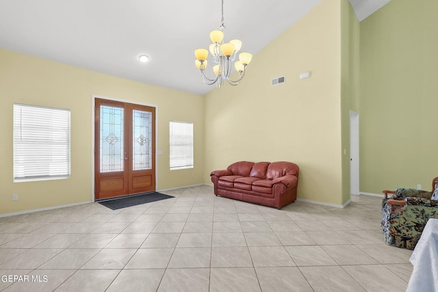 foyer entrance featuring high vaulted ceiling, light tile patterned flooring, baseboards, a notable chandelier, and visible vents