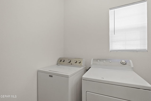 clothes washing area featuring separate washer and dryer and laundry area