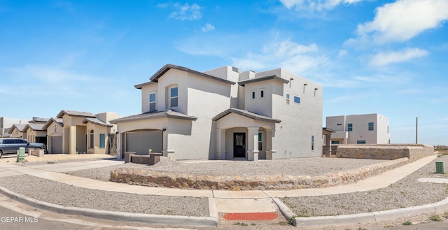 view of front of house featuring concrete driveway, an attached garage, and stucco siding