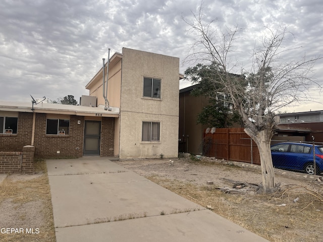 view of front facade featuring fence and stucco siding