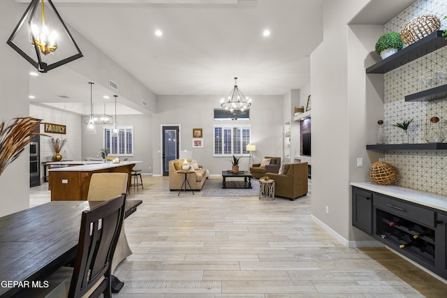 dining area featuring baseboards, an inviting chandelier, visible vents, and light wood-style floors