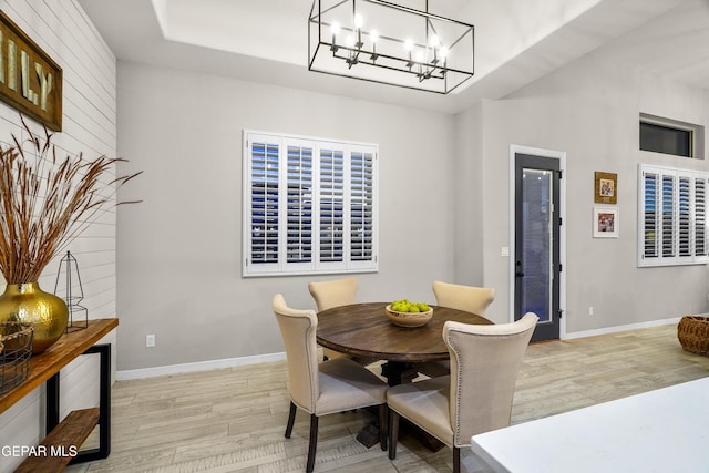 dining room with baseboards, light wood finished floors, and a chandelier