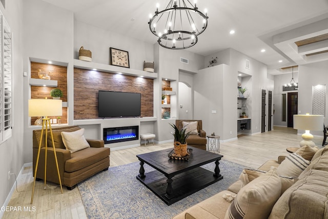 living room with visible vents, a notable chandelier, and light wood-type flooring