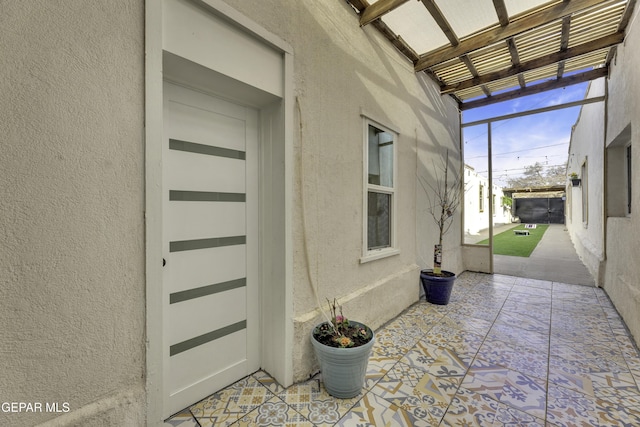 entrance to property with a patio and stucco siding