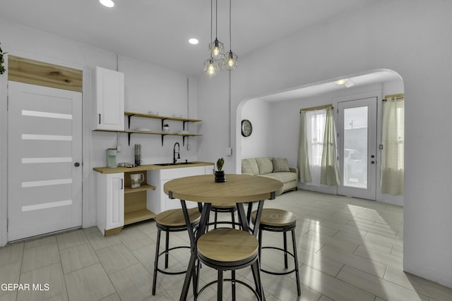 dining space with arched walkways and recessed lighting