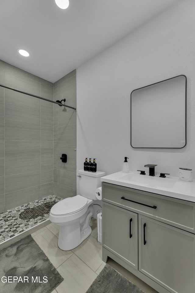full bath with recessed lighting, toilet, vanity, and tiled shower