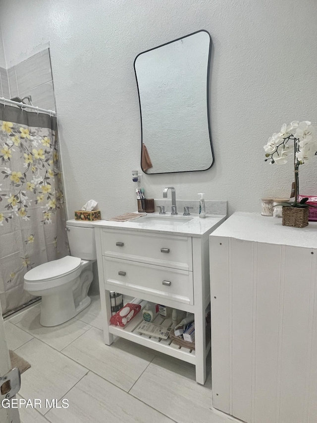 full bathroom featuring toilet, a textured wall, vanity, and curtained shower