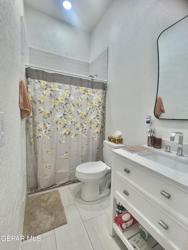 full bathroom featuring a textured wall, toilet, vanity, and a shower with curtain