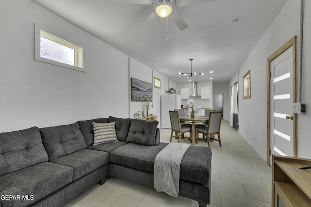 living room with ceiling fan with notable chandelier