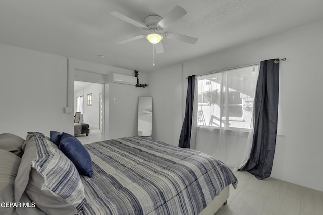 bedroom featuring a ceiling fan and a wall unit AC