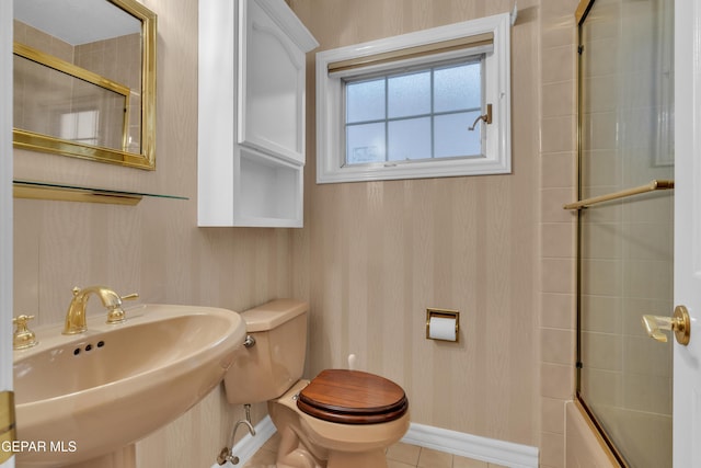 full bath featuring shower / bath combination with glass door, a sink, tile patterned flooring, toilet, and baseboards