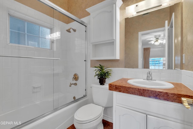 full bath featuring toilet, a ceiling fan, combined bath / shower with glass door, and vanity